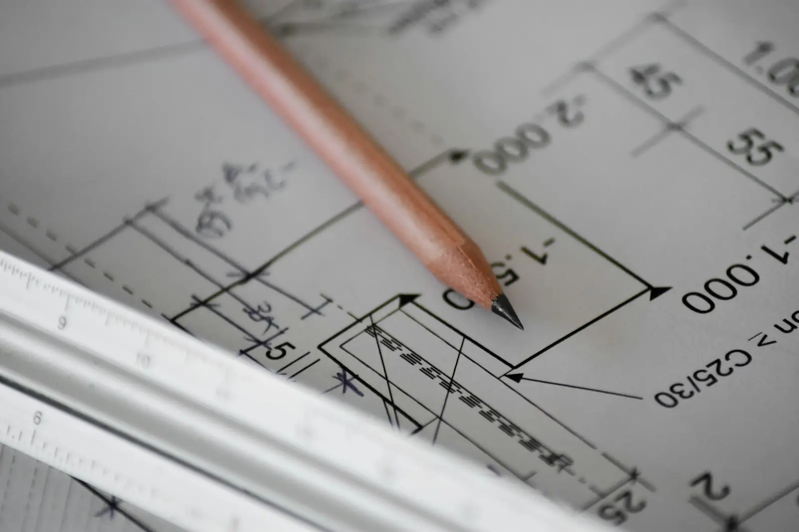 Lápiz sobre un plano arquitectónico con cotas y escalímetro